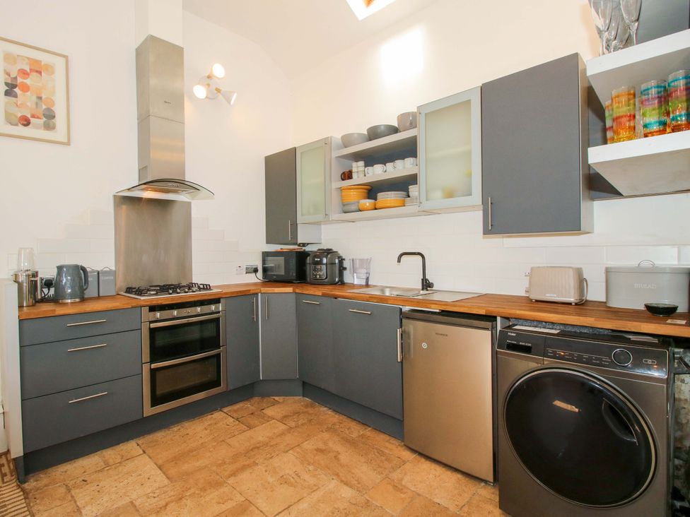 A kitchen with appliances and cabinets at The Lime Kiln Keepers Cottage in Ellesmere