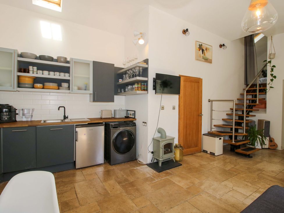 A kitchen with cabinets and appliances at The Lime Kiln Keepers Cottage in Ellesmere