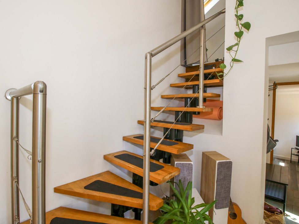 A staircase with wooden steps and a handrail at The Lime Kiln Keepers Cottage in Ellesmere