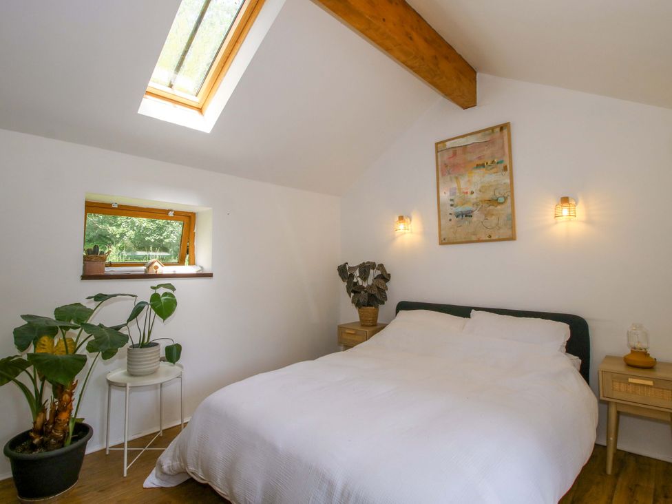 A bedroom with a bed and plants at The Lime Kiln Keepers Cottage in Ellesmere