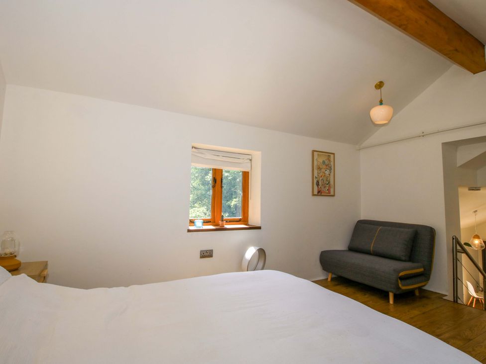 A bedroom with a bed and a sofa at The Lime Kiln Keepers Cottage in Ellesmere