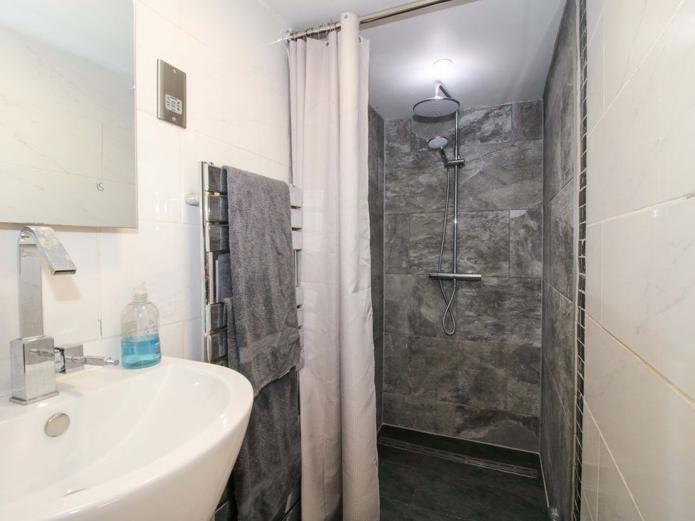 A bathroom with a shower and basin at The Lime Kiln Keepers Cottage in Ellesmere