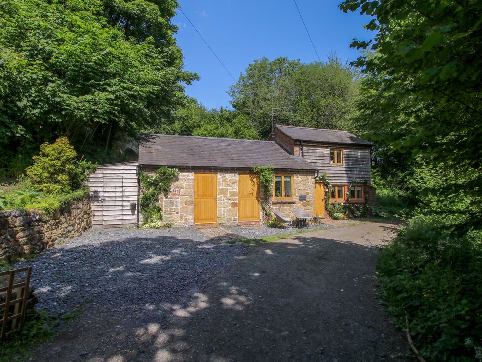 A cottage with stone walls and wooden structure at The Lime Kiln Keepers Cottage Ellesmere