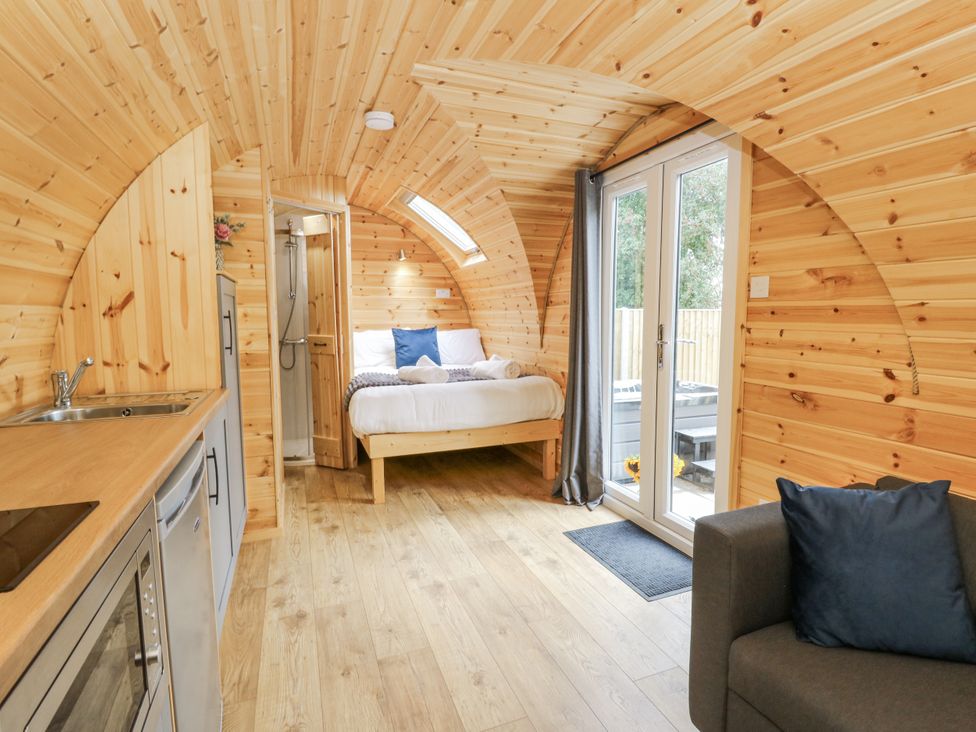 A studio with wooden walls and a bed at Oak View in Rhayader