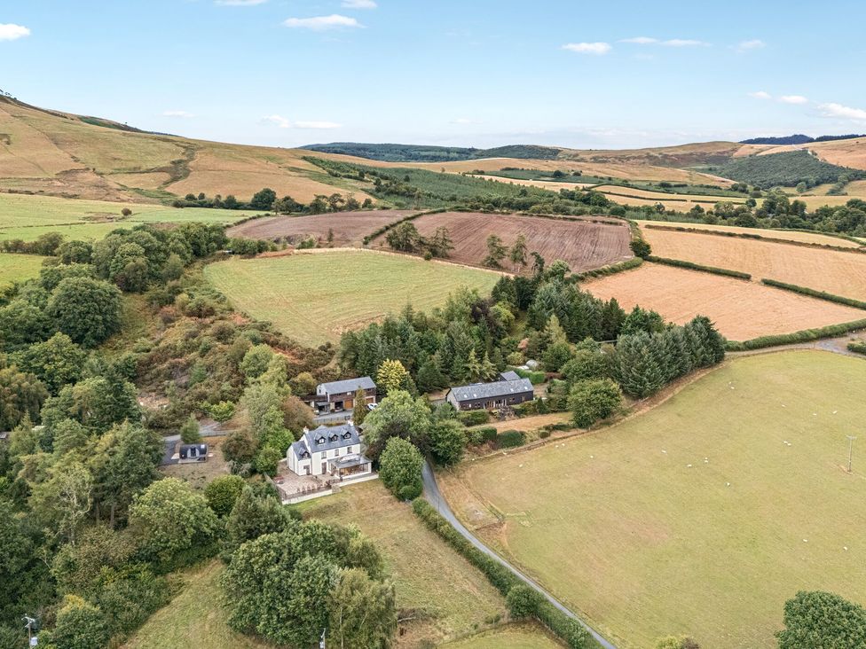 A house surrounded by fields and trees at Oak View in Rhayader