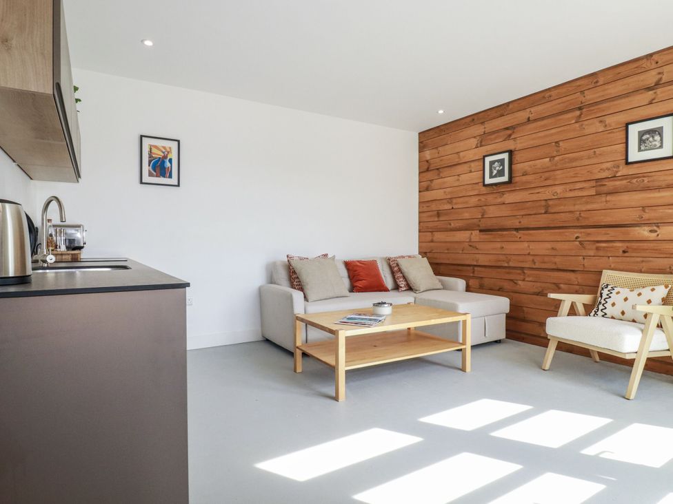 A living room with a sofa and coffee table at Teach Tra West in Perranporth