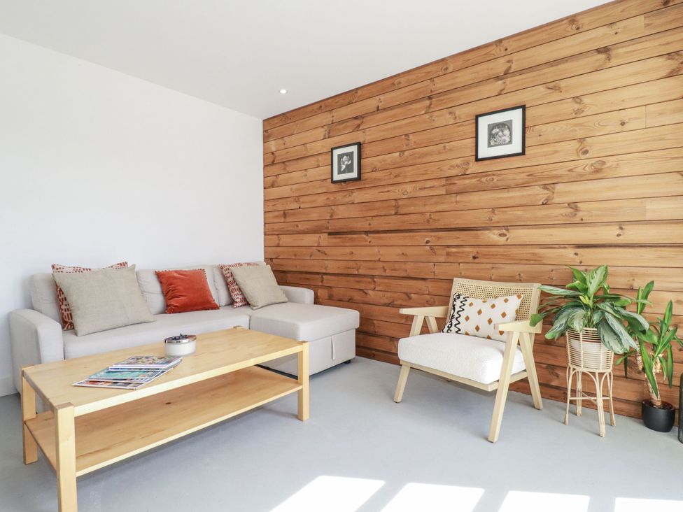 A living room with a sofa and coffee table at Teach Tra West in Perranporth