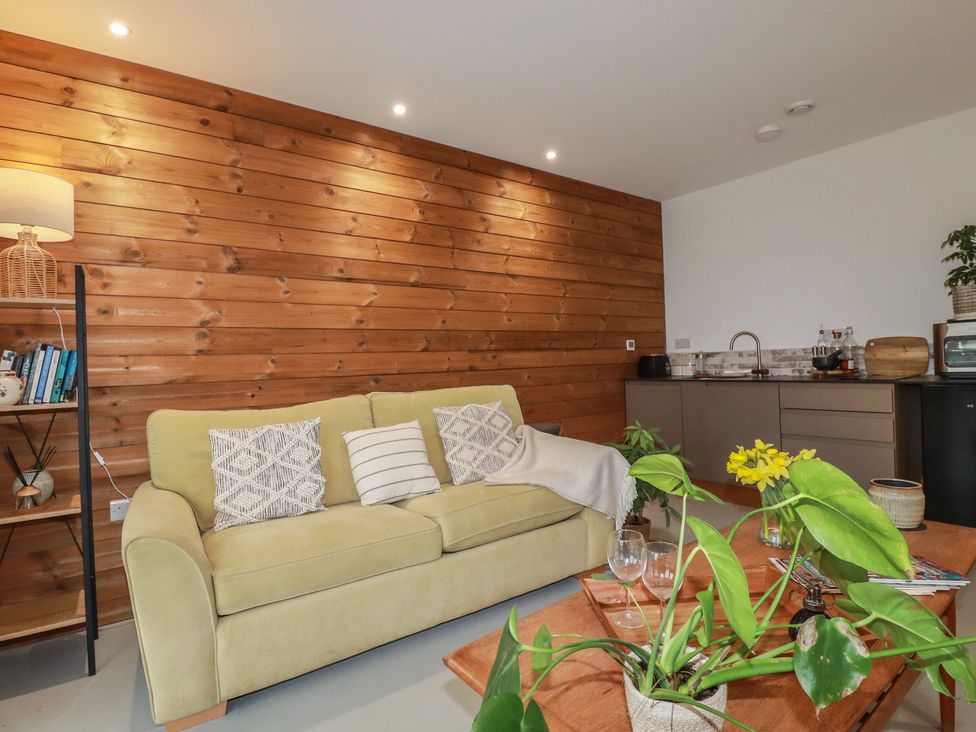 A living room with a sofa and coffee table at Teach Tra West in Perranporth