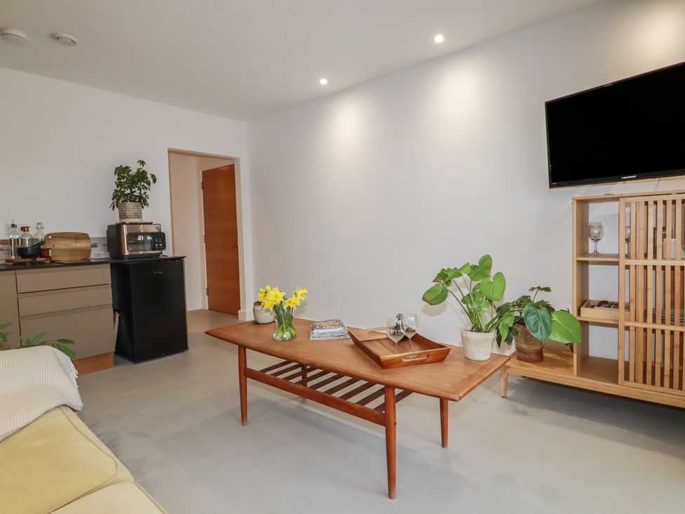 A living room with a coffee table and plants at Teach Tra West in Perranporth