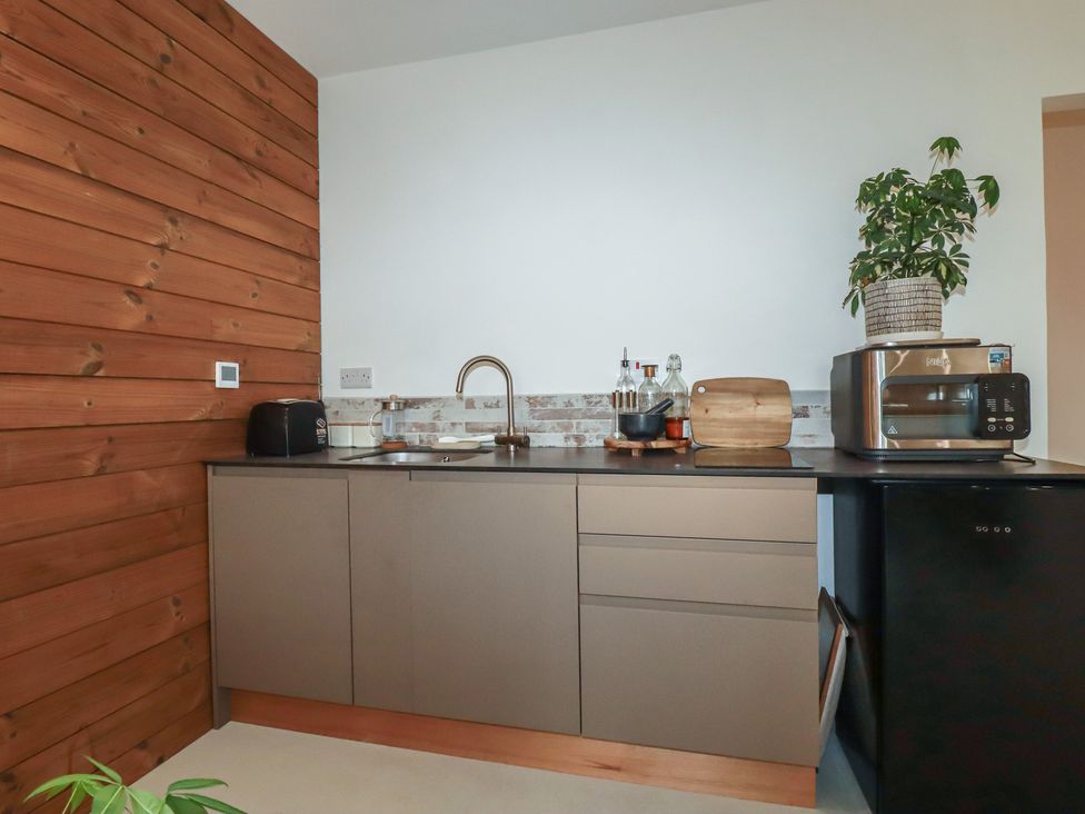 A kitchen with cabinets and appliances at Teach Tra West in Perranporth