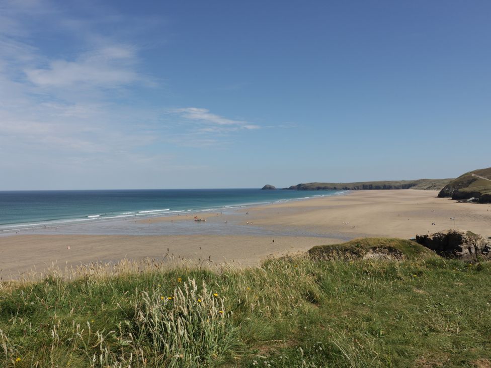 A beach with sand and ocean at Teach Tra West in Perranporth