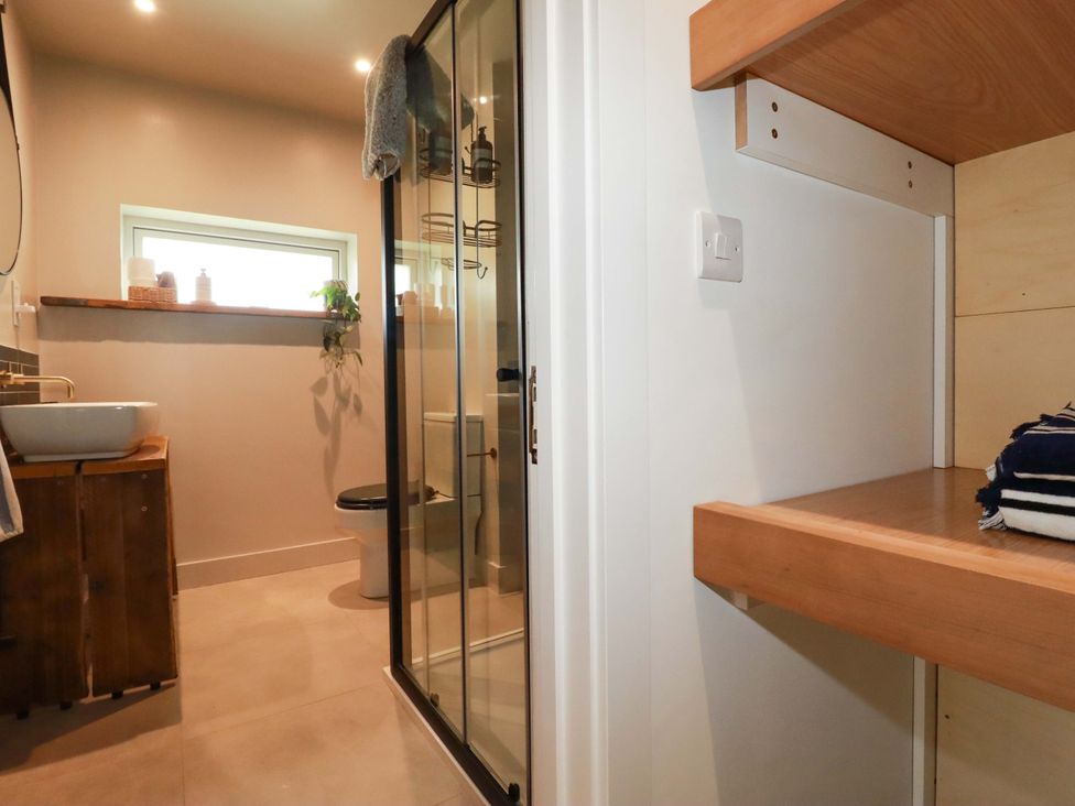 A bathroom with a shower, toilet, and sink at Teach Tra West in Perranporth