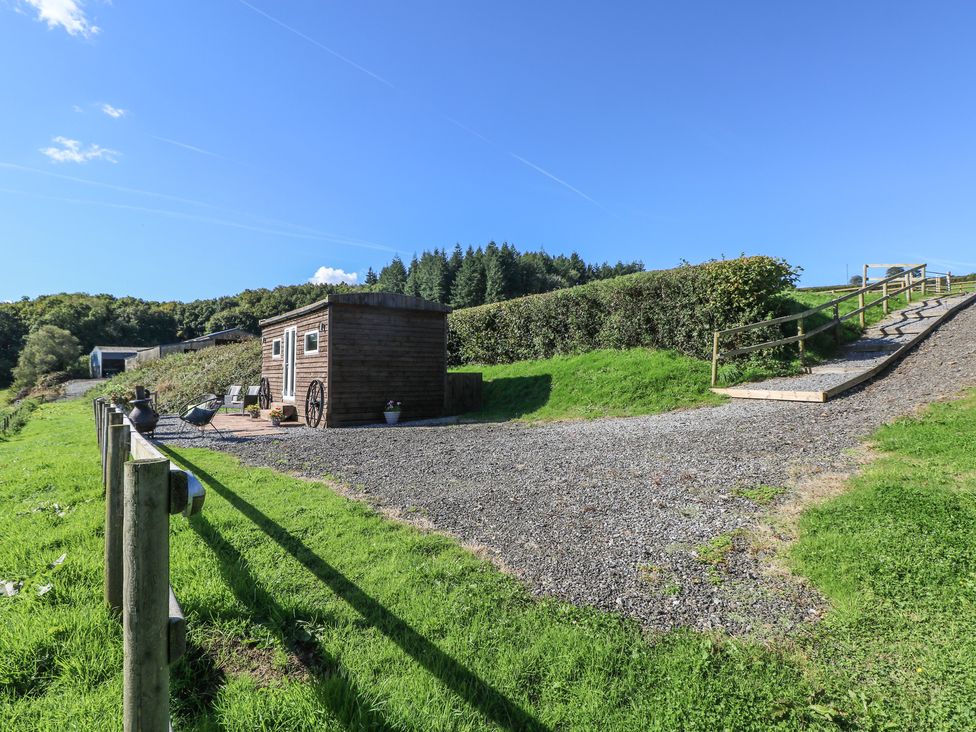 An outdoor area with a small building and gravel path at Sychnant Farm Retreat Llanedi near Pontarddulais