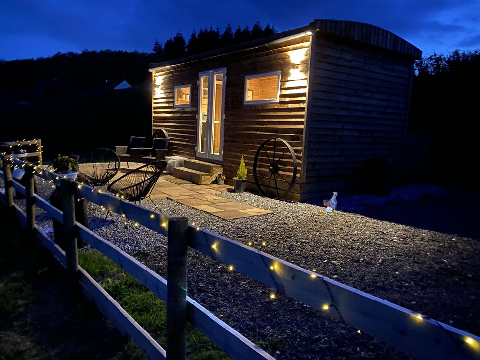 A wooden cabin with a deck and gravel surroundings at Sychnant Farm Retreat Llanedi near Pontarddulais