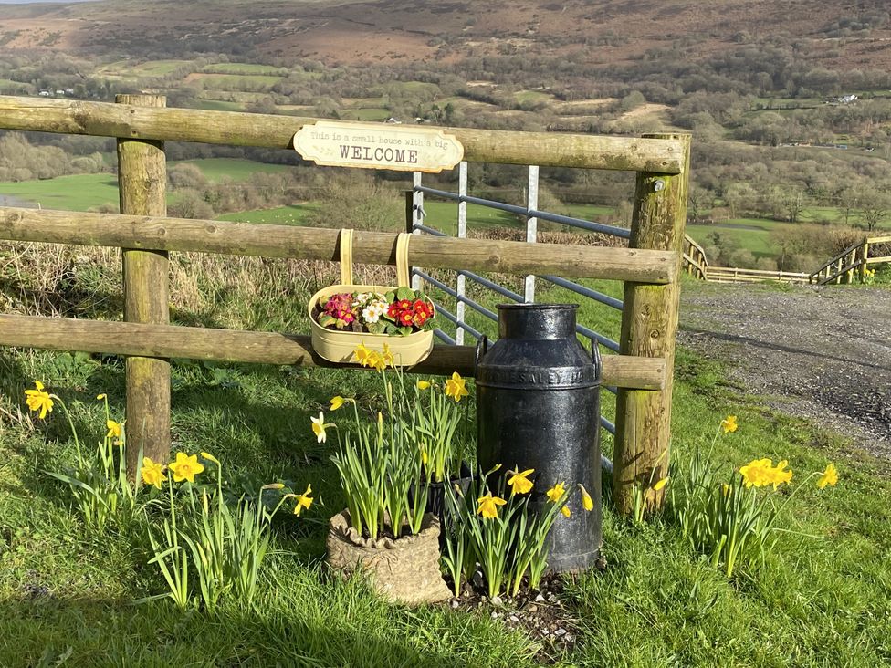 A gate with a sign and flowers at Sychnant Farm Retreat in Llanedi near Pontarddulais