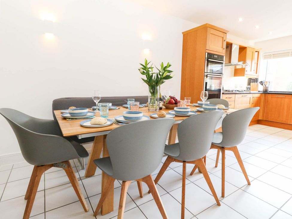 A dining room with a table set for meals at Harbour Heights in Weymouth