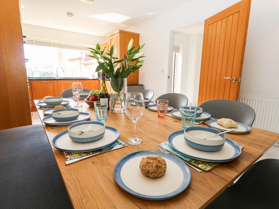 A dining table set with plates and glasses in the kitchen at Harbour Heights Weymouth