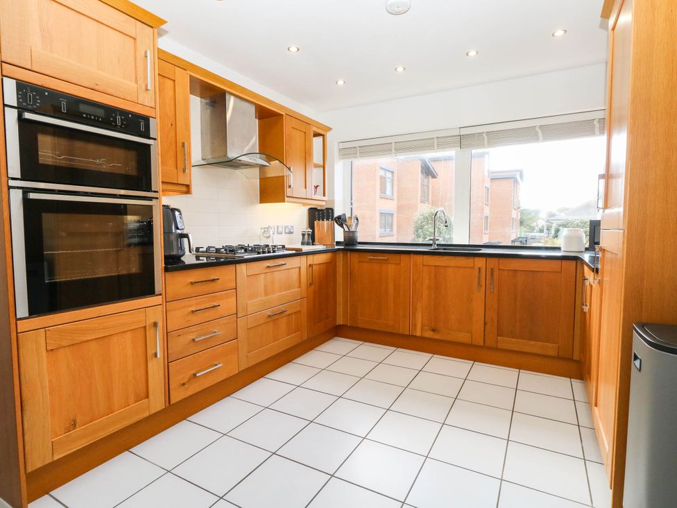 A kitchen with wooden cabinets and appliances at Harbour Heights in Weymouth