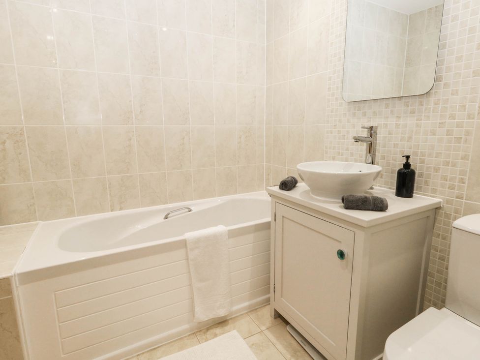 A bathroom with a bathtub, sink, and toilet at Harbour Heights in Weymouth