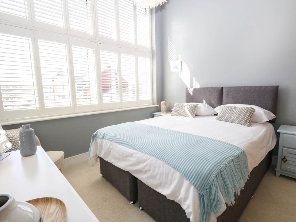 A bedroom with a bed and window shutters at Harbour Heights in Weymouth