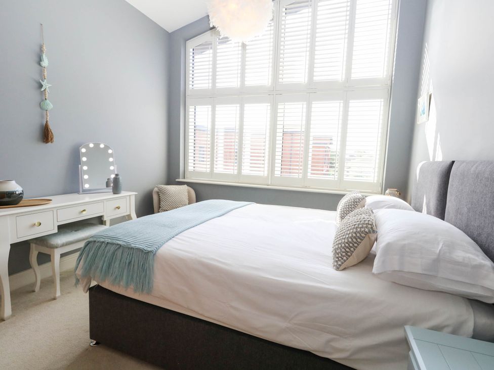 A bedroom with a bed and dressing table at Harbour Heights in Weymouth