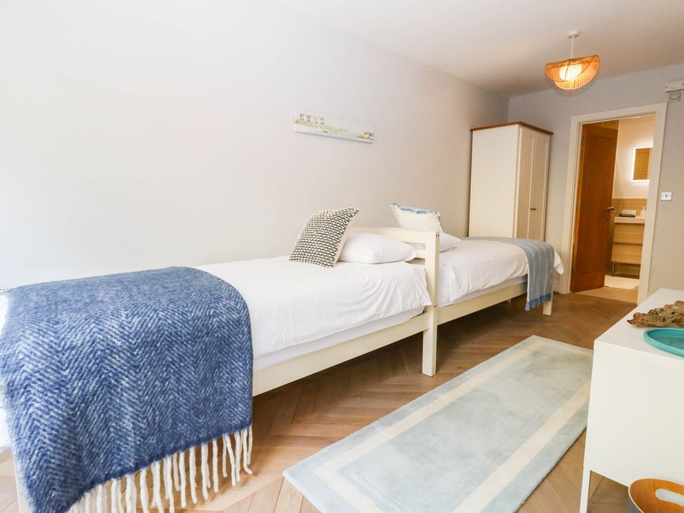 A bedroom with two beds and a wardrobe at Harbour Heights in Weymouth