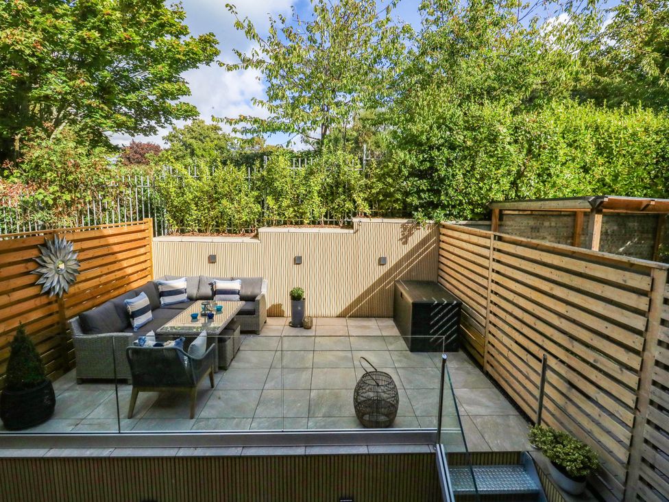 An outdoor garden with seating area and planters at Harbour Heights in Weymouth