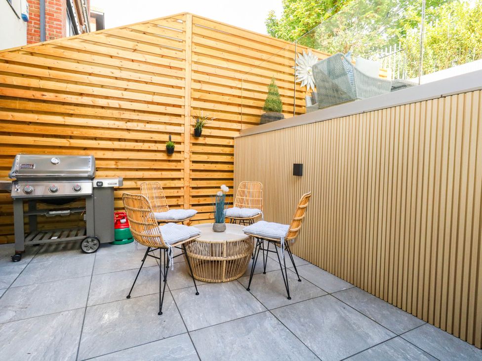 An outdoor seating area with a grill and chairs at Harbour Heights in Weymouth