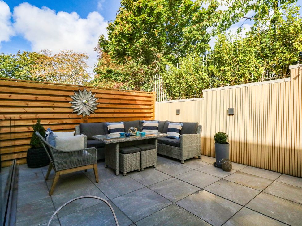 A garden area with a seating arrangement and a decorative wall piece at Harbour Heights Weymouth