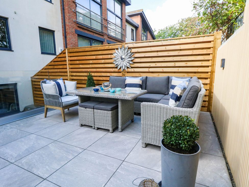 An outdoor patio with seating and a table at Harbour Heights in Weymouth