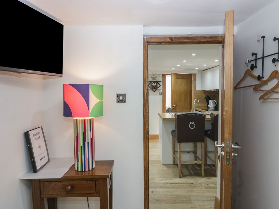 A kitchen area with a lamp and bar stools at Park View Studio in Ambleside