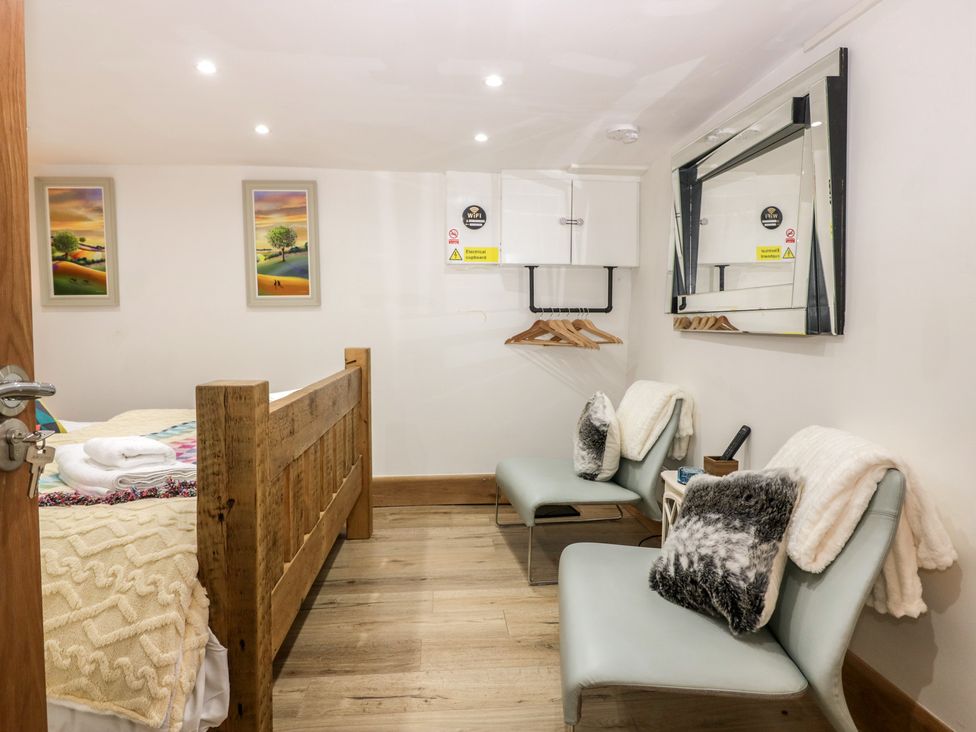 A bedroom with a bed and two chairs at Park View Studio in Ambleside
