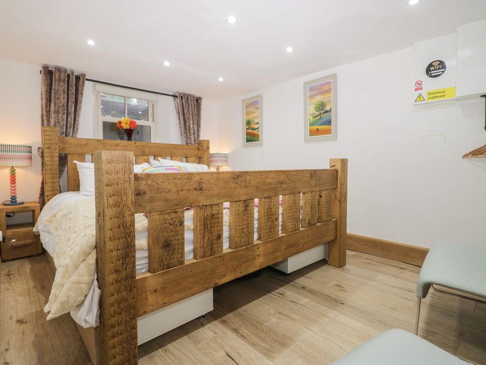 A bedroom with a wooden bed and nightstands at Park View Studio in Ambleside