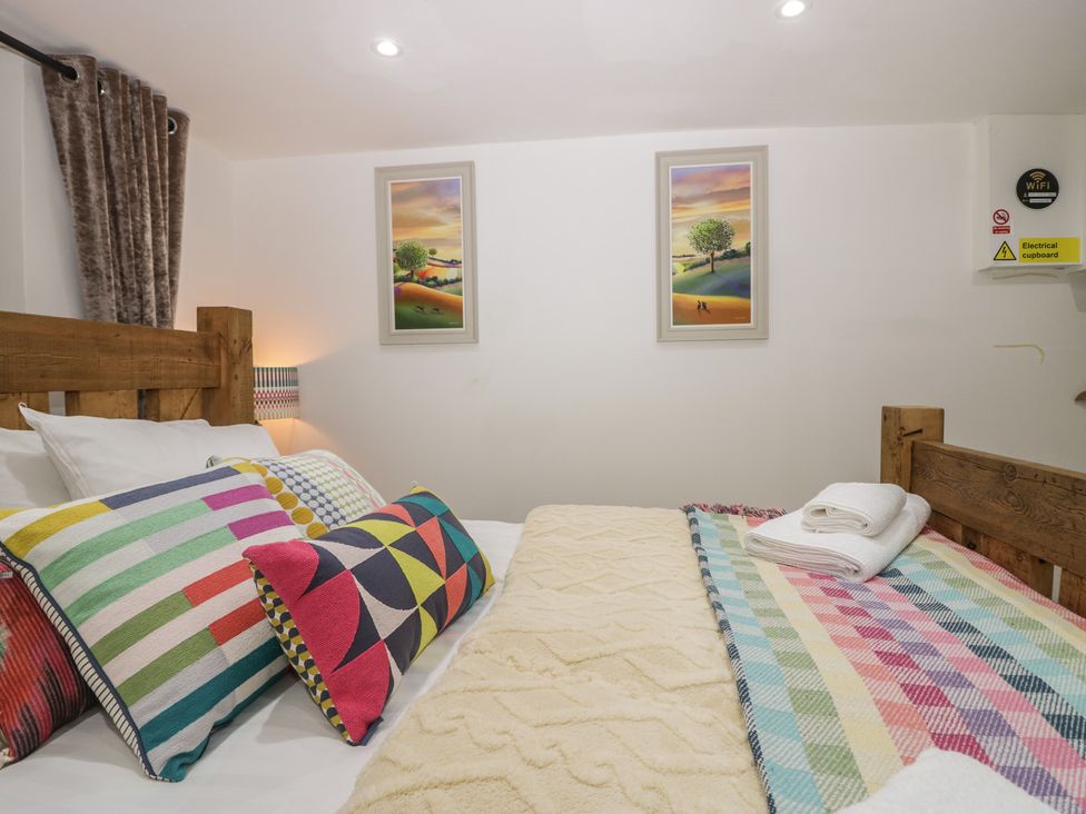 A bedroom with bed and colorful pillows at Park View Studio in Ambleside