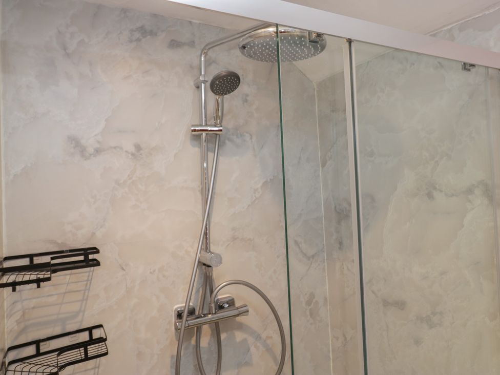 A shower area with showerhead and glass panel at Park View in Ambleside