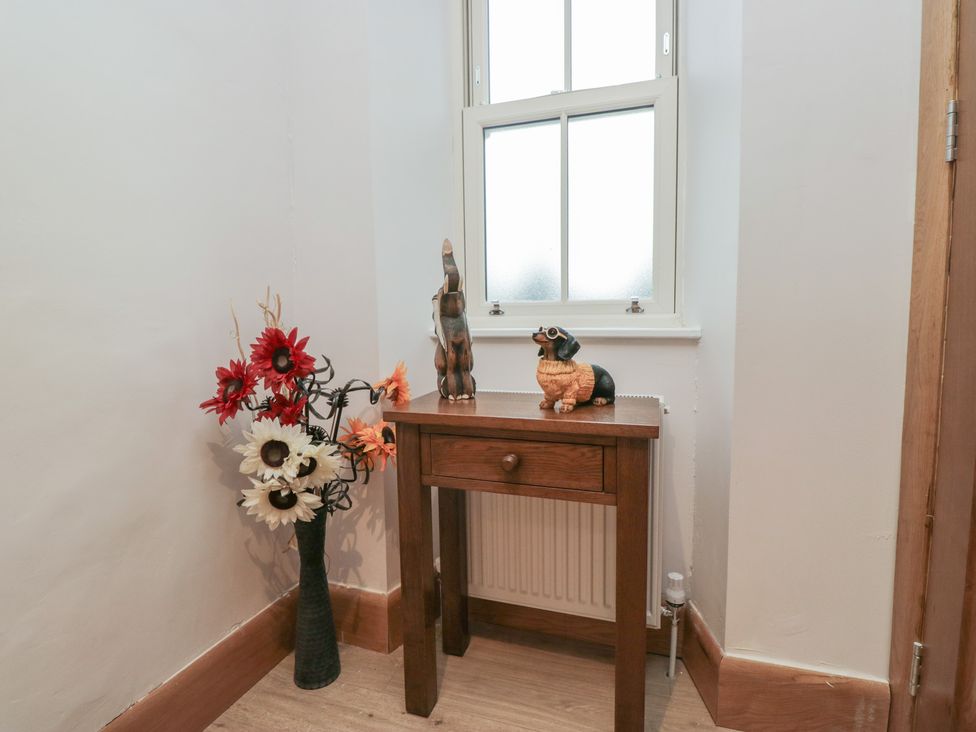 A hallway with a table and decorative items at Park View in Ambleside