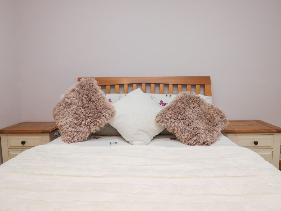 A bed with pillows and bedside tables at Park View in Ambleside