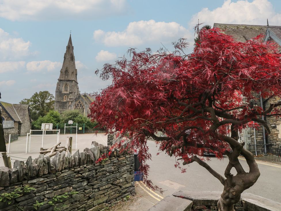 A church and a red tree in a playground area at Park View in Ambleside
