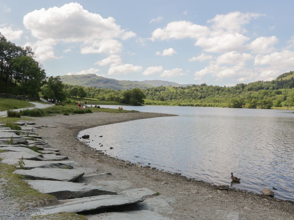 A lake with a shoreline and people walking at Park View in Ambleside