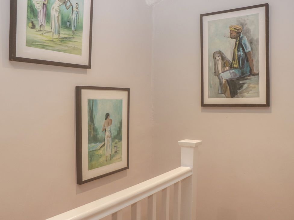 A hallway with framed paintings on the wall at Park View in Ambleside