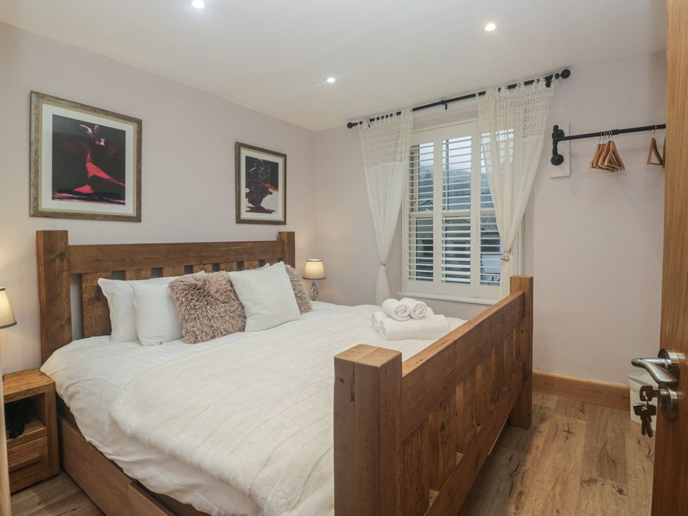 A bedroom with a wooden bed and nightstand at Park View in Ambleside