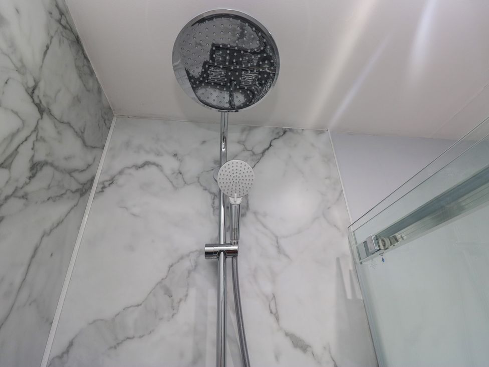 A shower area featuring a rain shower head and marble wall at Park View in Ambleside