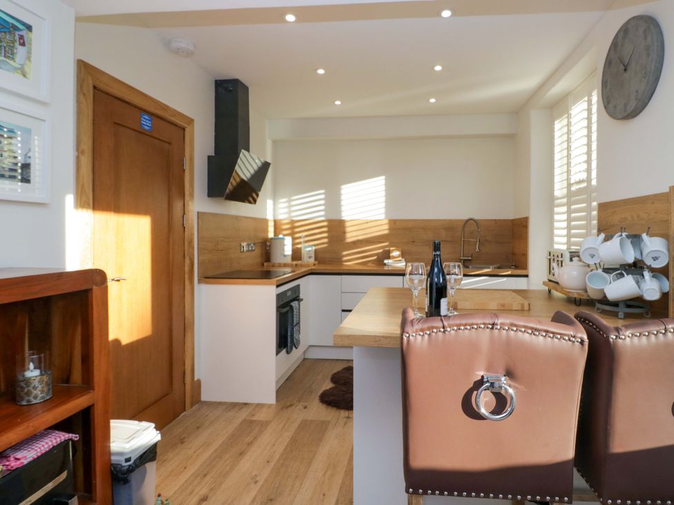 A kitchen with chairs and a wine bottle at Park View in Ambleside