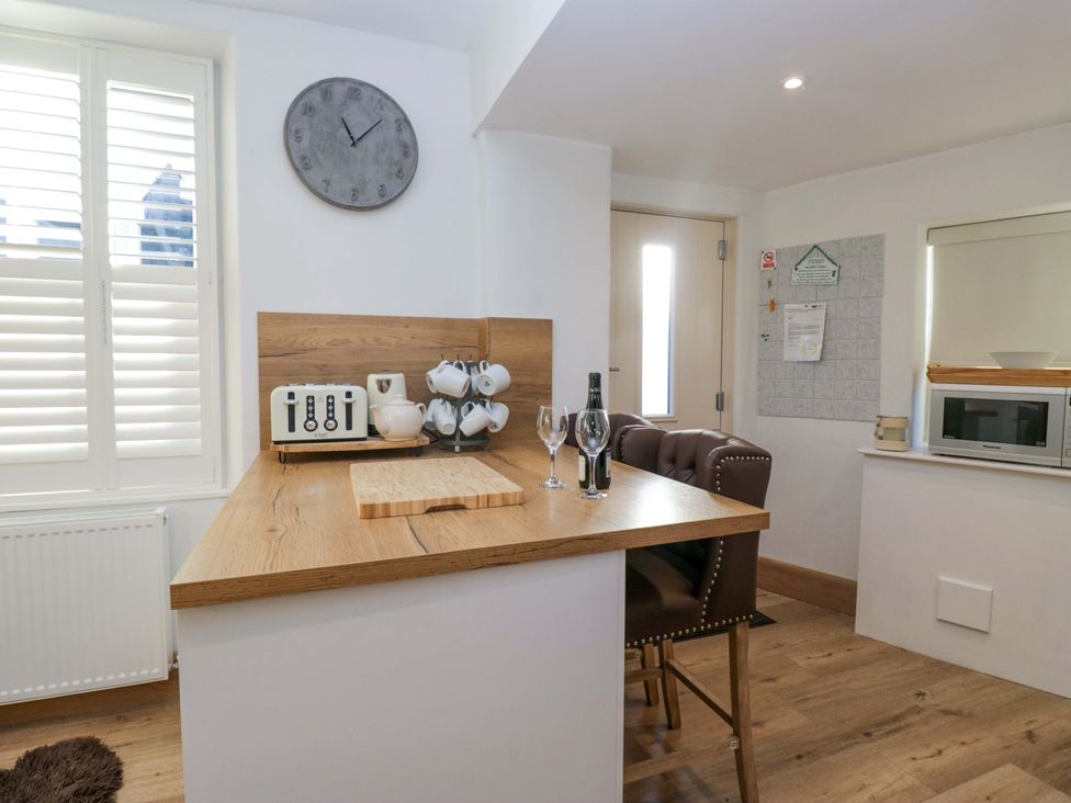 A kitchen with a countertop and bar stools at Park View in Ambleside