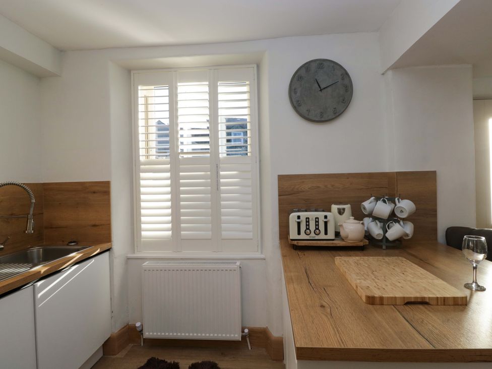 A kitchen with a sink and clock at Park View in Ambleside