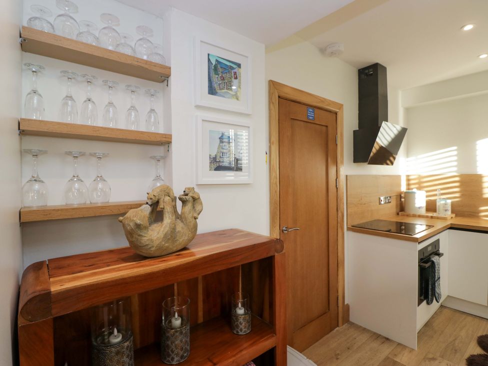 A kitchen with glasses on a shelf and a decorative item on a wooden surface at Park View in Ambleside