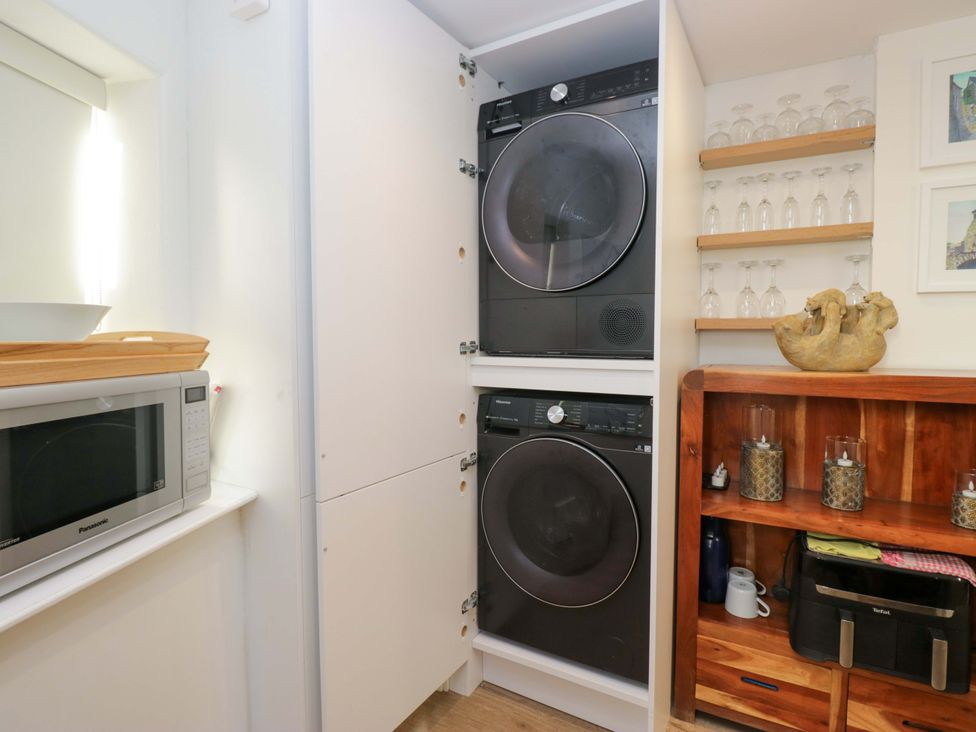 A laundry room with a washing machine, dryer and microwave at Park View in Ambleside