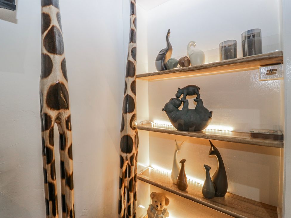 A shelving unit with animal figurines and a teddy bear at Park View in Ambleside