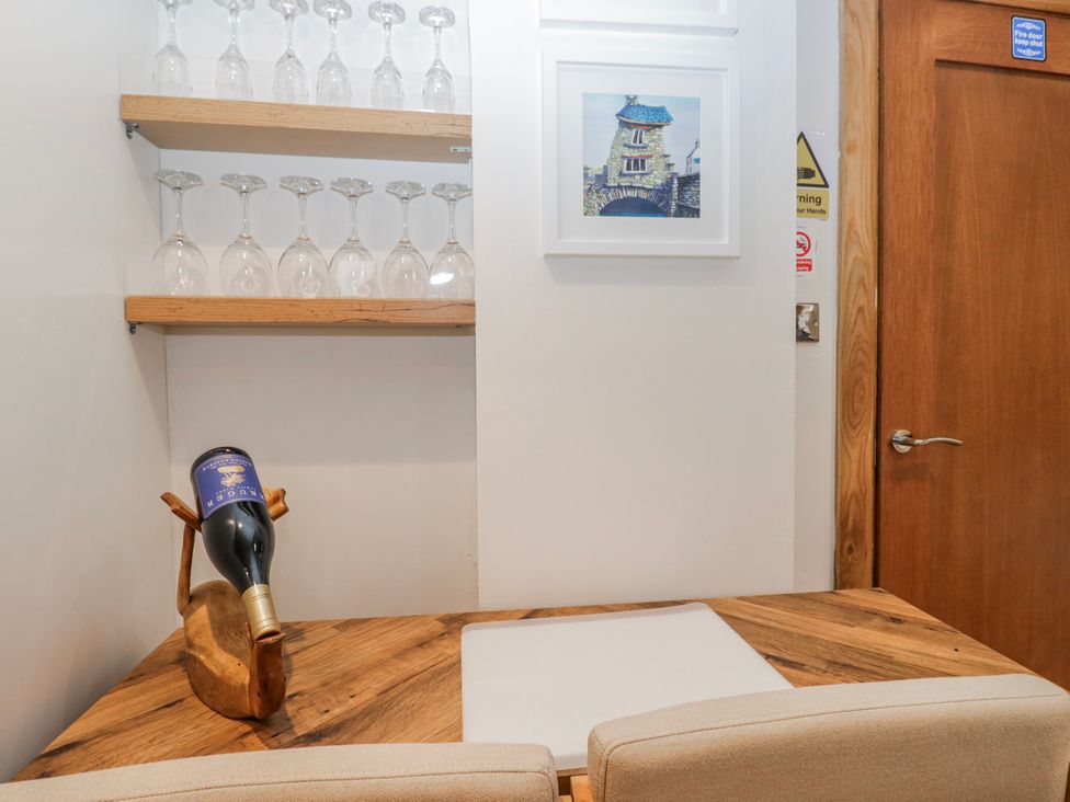A dining room with a wine bottle and glasses on a shelf at Park View in Ambleside