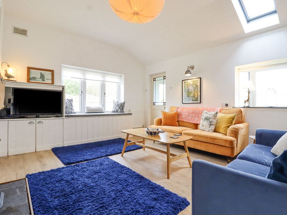 A living room with a sofa and TV at Greengates in Rye